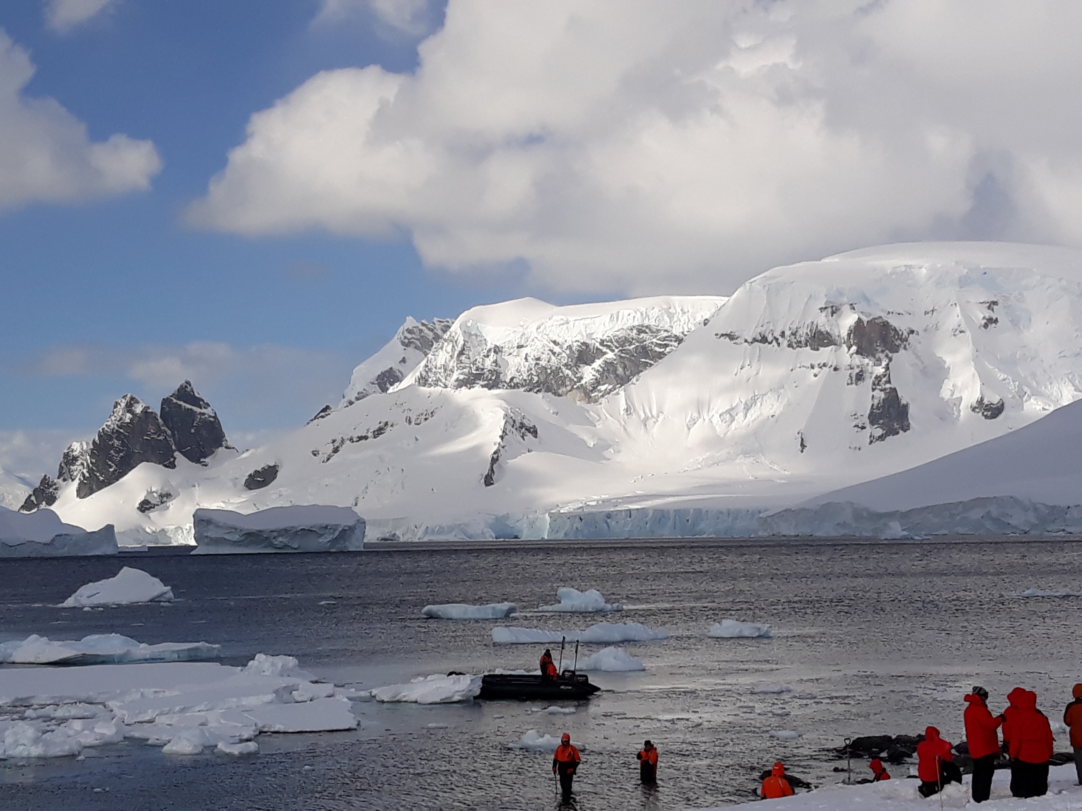 Icy mountain landscape with several people in foreground